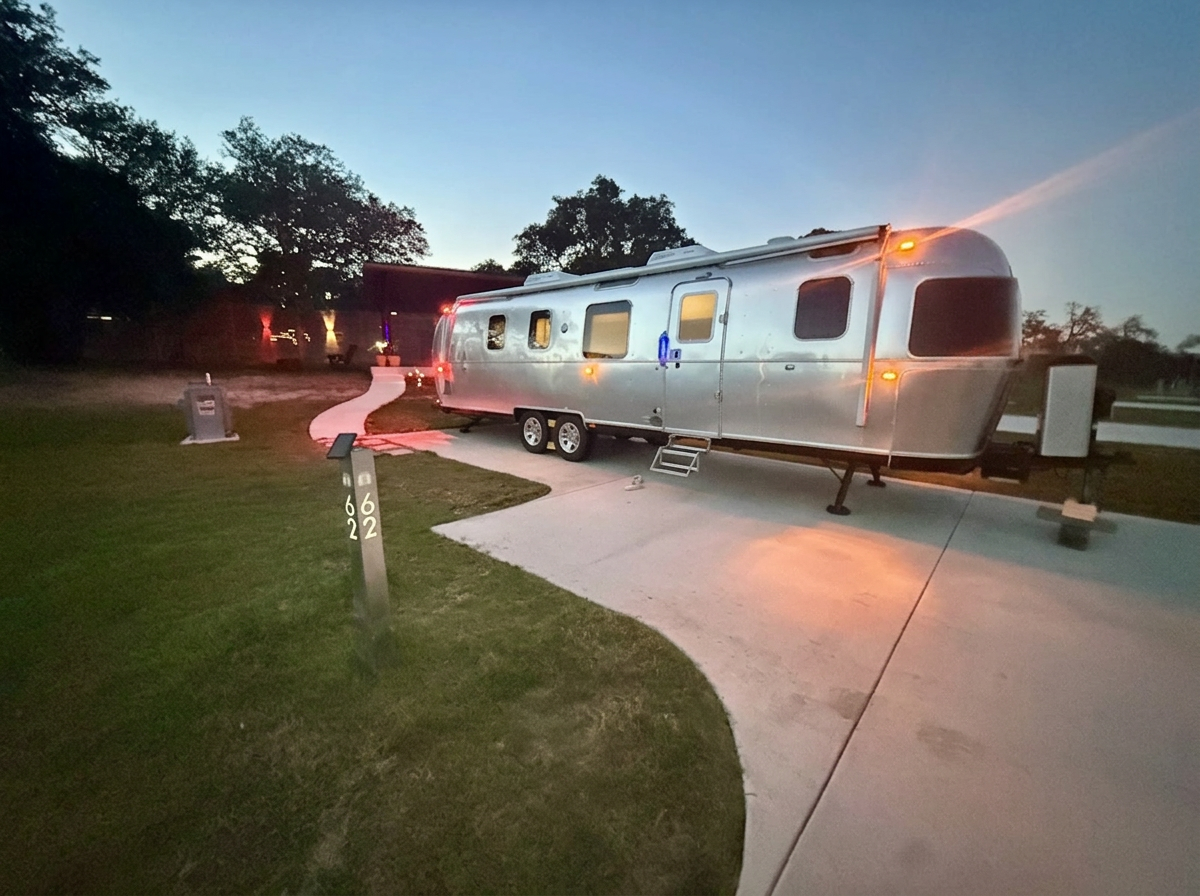 An Airstream settled onto Site 062 at dusk
