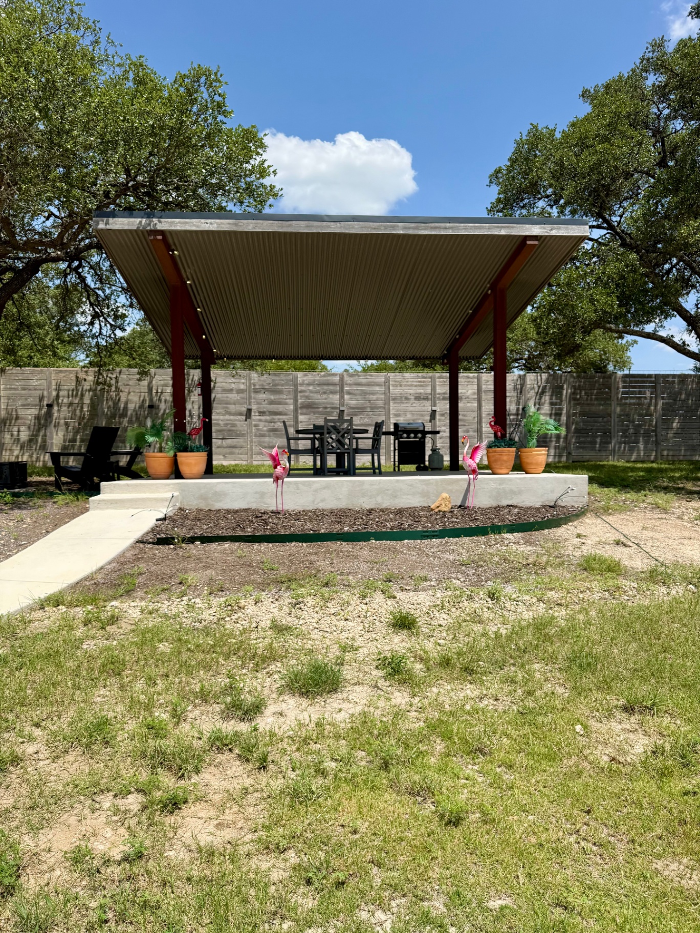 The covered pavilion at Site 062 with dining set, grill and pink flamingo lawn ornaments